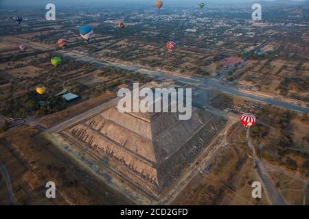 I mongolfiera si innalzano nell'aria di prima mattina sopra la Piramide del Sole presso il sito archeologico di Teotihuacan vicino a Città del Messico, Messico Foto Stock