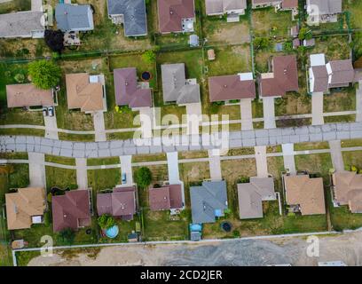 Vista aerea di piccole case cittadine su strada in paesaggio dall'alto della zona residenziale Foto Stock