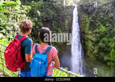 Hawaii Akaka Falls turisti a cascata hawaiiana. Giovane coppia backpackers guardando acqua caduta su Hawaii, Big Island, Stati Uniti. Viaggi turismo persone Foto Stock