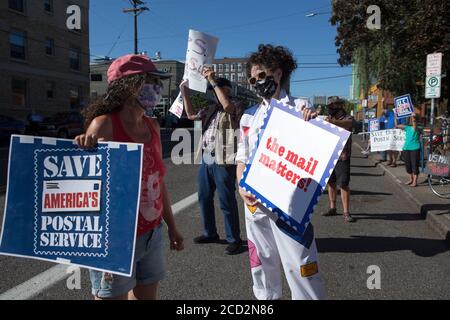 Portland, Oregon, Stati Uniti. 25 Agosto 2020. LAURA GLAZER, a destra, di Portland, Oregon, con un cartello che recita ''The mail Matters'' parla con Jodi ZEISEL, a sinistra, mentre partecipa a una Giornata d'azione al di fuori dell'Ufficio postale di Portland orientale martedì 25 agosto 2020. GLAZER ha detto, ''il servizio postale è un modo per connettersi ad altre persone. È un thread che collega tutti noi, indipendentemente da ciò che crediamo. Lettere e pacchetti sono anche un modo per inviare un pezzo di noi stessi a persone che amiamo o che vogliamo amare.'' ZEISEL si è rivolto prima alla folla e ha ricordato di aver ricevuto pac Foto Stock