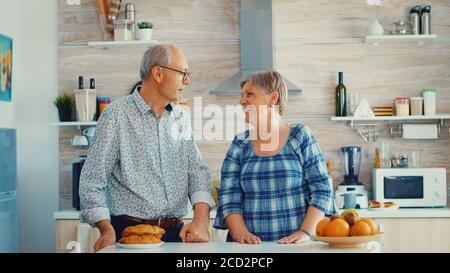 Portret slow motion di coppia senior in cucina sorridente l'uno all'altro e guardando la fotocamera. Allegra moglie e marito. Foto Stock
