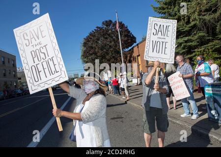 Portland, Oregon, Stati Uniti. 25 Agosto 2020. LISA FLORENTINO, a sinistra, e suo marito PATRICK KERNAN, a destra, di Portland, Oregon, hanno firmato per assomigliare ai francobolli durante la partecipazione a un giorno d'azione al di fuori dell'ufficio postale di Portland orientale. Credit: Katharine Kimball/ZUMA Wire/Alamy Live News Foto Stock