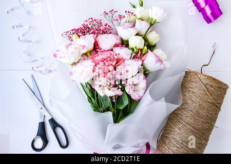 Fiorista proprietario di affari del posto di lavoro fiorista che fa o che organizza gilet di fiori artificiali nel suo negozio, artigianato e concetto fatto a mano. Vista dall'alto Foto Stock