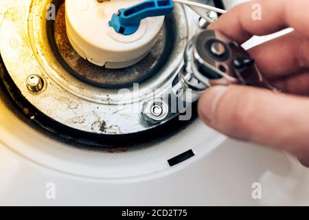 riparazione delle caldaie, la mano del master lancia e attorciglia i dadi, primo piano. Foto Stock