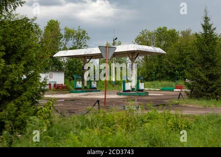 Nizhny Novgorod, Russia - 9 luglio 2020: Vuoto vecchia stazione di gas rurale, distributori con benzina e diesel fuel.Post paesaggio apocalittico. cag carburante vecchio Foto Stock