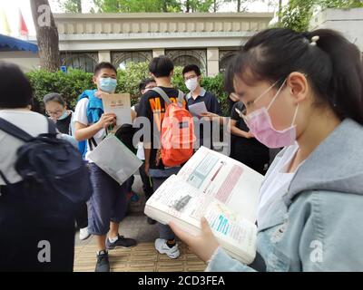 Gli studenti esaminano i libri prima di entrare nel centro di test per gli esami nell'ultimo giorno dell'ingresso del National College 2020, noto anche come Gaokao, Nanjin Foto Stock