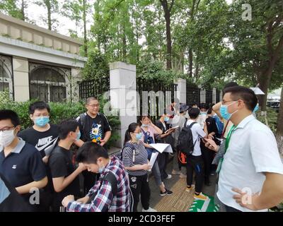 Gli studenti esaminano i libri prima di entrare nel centro di test per gli esami nell'ultimo giorno dell'ingresso del National College 2020, noto anche come Gaokao, Nanjin Foto Stock