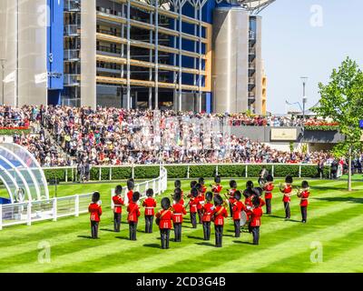I guardiani in uniformi rosse giocano nel Parade Ring e intrattengono la folla durante Royal Ascot, l'ippodromo di Ascot, l'Ascot Berkshire Foto Stock