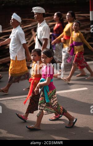 Galungan Holiday.Festive processione di donne in abiti tradizionali. Due ragazze in primo piano. Isola di Bali, Indonesia.26.12.2018. Foto Stock