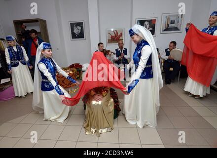 Cerimonia tradizionale di nozze di Crimea Tartar: Bridesmaids preparare una sposa per incontrare uno sposo coprendo il suo panno rosso. Giorni di Tartar cultu Crimea Foto Stock