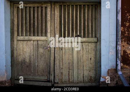 Vecchia porta di legno che porta al garage o cortile Foto Stock