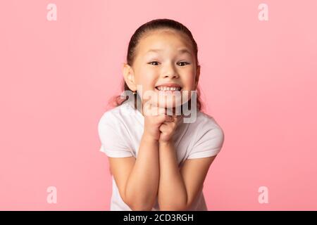 Giovane ragazza asiatica speranzosa che prega per qualcosa Foto Stock