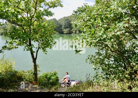 Una coppia si rilassa sul molo del traghetto N17 dei bacini umidi di walthamstow Lane london inghilterra Regno Unito Foto Stock