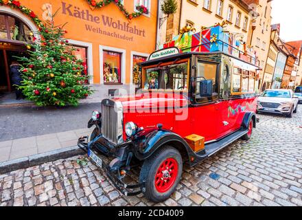 Rothenburg ob der Tauber, Germania - Dicembre 2018: Auto rossa retrò nei pressi di un negozio che vende regali di Natale tradizionali nella città vecchia medievale in Baviera Foto Stock