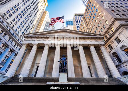 La famosa Wall Street e la costruzione della Federal Hall con bandiera patriota a New York, Stati Uniti. Foto Stock