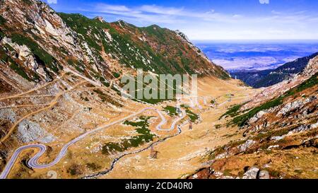 Strada tortuosa Transfagarasan attraverso i Monti Carpazi in autunno. Vista aerea dal drone in Romania. Foto Stock