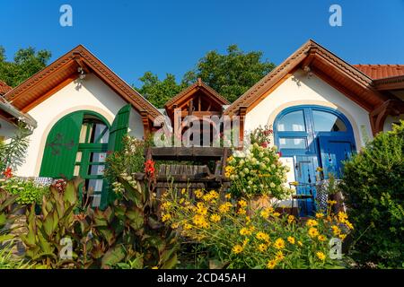 Colorate case stampa piccole nane in pecs Ungheria con molti fiori Foto Stock