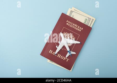 Aereo sulla copertura di un passaporto russo. Dollari. Concetto di viaggio. Sfondo blu Foto Stock