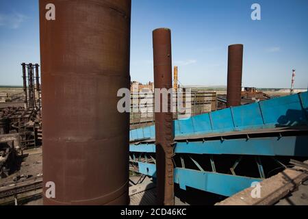 Abbandonati edifici della fabbrica di metallurgia sovietica e camini arrugginiti sul cielo blu. Vista panoramica. Foto Stock