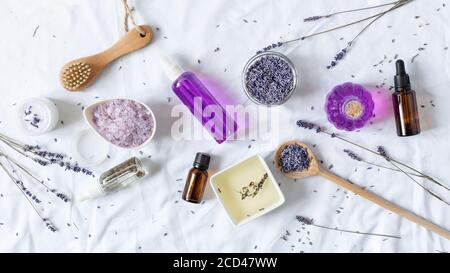 Varietà di cosmetici biologici di lavanda su sfondo bianco vista dall'alto. Cosmetici a base di erbe con fiori di lavanda. Foto Stock