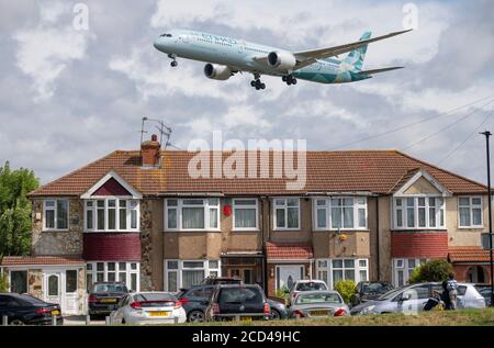 Aeroporto di Heathrow, Londra, Regno Unito. 26 agosto 2020. Donna e bambino giovane guardano un Etihad Boeing 787 Dreamliner su Myrtle Avenue in avvicinamento alla pista 27L a Heathrow in vento di raffica, i resti di Storm Francis. La pandemia di COVID-19 ha visto il crollo dell'industria aerea in tutto il mondo, con circa il 11% dei passeggeri a Heathrow nel luglio 2020 rispetto allo stesso mese del 2019, e circa il 25% dei movimenti del traffico aereo a Heathrow nel luglio 2020 rispetto al luglio 2019. Credit: Malcolm Park/Alamy Live News. Foto Stock