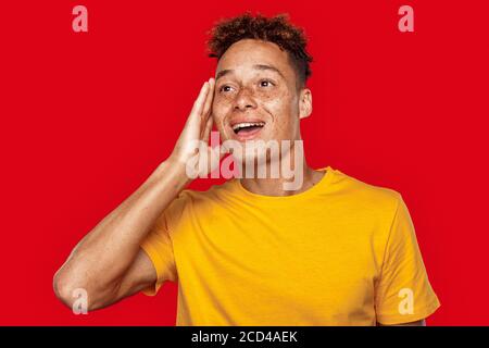 Giovane adulto maschio che guarda via con il volto eccitato Foto Stock