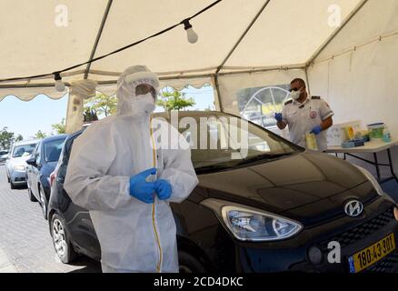 Gerusalemme Est, Israele. 26 Agosto 2020. Un operatore sanitario con il servizio di emergenza nazionale israeliano, Magen David Adam, indossa un equipaggiamento protettivo mentre prende i tamponi per testare COVID-19 in un centro di test drive through a Gerusalemme Est, mercoledì 26 agosto 2020. Per la prima volta questo mese, il numero di casi giornalieri COVID-19 in Israele ha quasi superato i 2,000 ed è diffuso nelle comunità arabe. Foto di Debbie Hill/UPI Credit: UPI/Alamy Live News Foto Stock