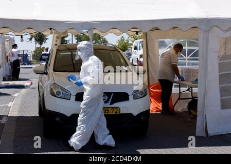 Gerusalemme Est, Israele. 26 Agosto 2020. Un operatore sanitario con il servizio di emergenza nazionale israeliano, Magen David Adam, indossa un equipaggiamento protettivo mentre prende i tamponi per testare COVID-19 in un centro di test drive through a Gerusalemme Est, mercoledì 26 agosto 2020. Per la prima volta questo mese, il numero di casi giornalieri COVID-19 in Israele ha quasi superato i 2,000 ed è diffuso nelle comunità arabe. Foto di Debbie Hill/UPI Credit: UPI/Alamy Live News Foto Stock