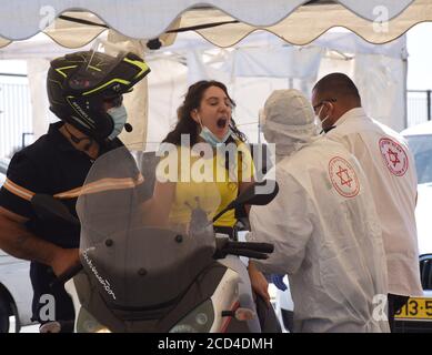 Gerusalemme Est, Israele. 26 Agosto 2020. Un operatore sanitario con il servizio di emergenza nazionale israeliano, Magen David Adam, indossa un equipaggiamento protettivo mentre prende i tamponi per testare COVID-19 in un centro di test drive through a Gerusalemme Est, mercoledì 26 agosto 2020. Per la prima volta questo mese, il numero di casi giornalieri COVID-19 in Israele ha quasi superato i 2,000 ed è diffuso nelle comunità arabe. Foto di Debbie Hill/UPI Credit: UPI/Alamy Live News Foto Stock