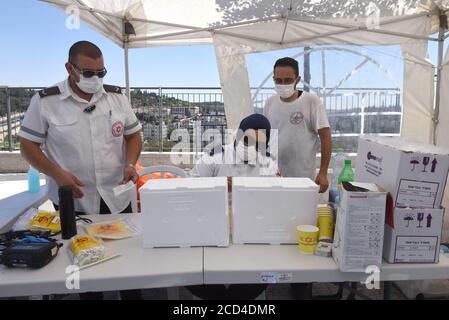 Gerusalemme Est, Israele. 26 Agosto 2020. Operatori sanitari con il servizio nazionale israeliano di emergenza, Magen David Adam, tamponi registro utilizzati per testare COVID-19 presso un centro di test drive through a Gerusalemme Est, mercoledì 26 agosto 2020. Per la prima volta questo mese, il numero di casi giornalieri COVID-19 in Israele ha quasi superato i 2,000 ed è diffuso nelle comunità arabe. Foto di Debbie Hill/UPI Credit: UPI/Alamy Live News Foto Stock