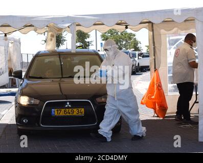 Gerusalemme Est, Israele. 26 Agosto 2020. Un operatore sanitario con il servizio di emergenza nazionale israeliano, Magen David Adam, indossa un equipaggiamento protettivo mentre prende i tamponi per testare COVID-19 in un centro di test drive through a Gerusalemme Est, mercoledì 26 agosto 2020. Per la prima volta questo mese, il numero di casi giornalieri COVID-19 in Israele ha quasi superato i 2,000 ed è diffuso nelle comunità arabe. Foto di Debbie Hill/UPI Credit: UPI/Alamy Live News Foto Stock