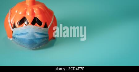 Zucca arancione che indossa una maschera medica protettiva. Foto Stock