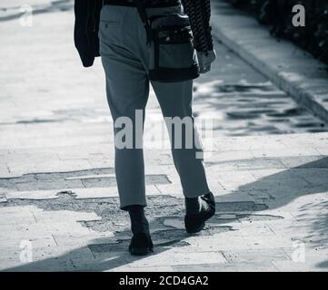 Giovane uomo che indossa loafer e pantaloni lunghi alla caviglia. Foto Stock