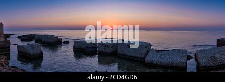 Splendida vista panoramica del tramonto sul Mar Mediterraneo in Sicilia, grandi rocce in primo piano Foto Stock