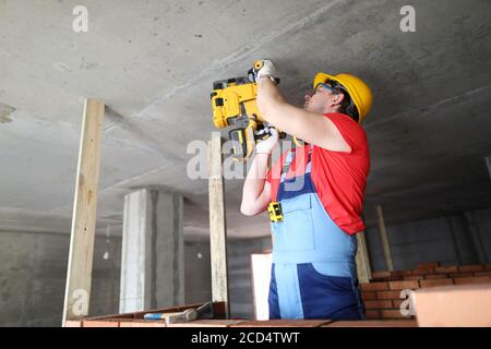 Builder lavora con attrezzature speciali a soffitto Foto Stock