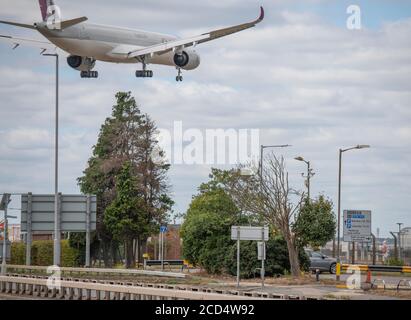 Aeroporto di Heathrow, Londra, Regno Unito. 26 agosto 2020. Qatar Airways Airbus A350 A7-ANK da Doha attraversa la A30 Great South West Road prima di scendere sulla pista 27L a Heathrow. La pandemia di COVID-19 ha visto il crollo dell'industria aerea in tutto il mondo, con circa il 11% dei passeggeri a Heathrow nel luglio 2020 rispetto allo stesso mese del 2019, e circa il 25% dei movimenti del traffico aereo a Heathrow nel luglio 2020 rispetto al luglio 2019. Credito: Malcolm Park/Alamy. Foto Stock