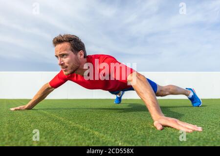 Ampia impugnatura pushup variazione push-up avanzato esercizio sul petto dimostrazione da allenatore maschile atleta allenatore in palestra all'aperto Foto Stock