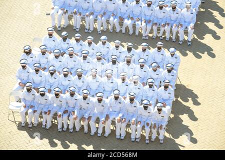 Gli armatori della marina della U.S. Naval Academy indossano maschere PPE durante la cerimonia del giuramento di ufficio del 18 luglio 2020 ad Annapolis, Maryland. Il giorno del giuramento segna l'inizio del periodo abbreviato di quattro settimane di indottrinamento chiamato Plobe Summer, destinato a trasferire i candidati dalla vita civile a quella militare. Foto Stock