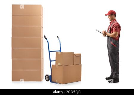 Foto di profilo a lunghezza intera di un lavoratore maschile che guarda una pila di scatole e la scrittura di un documento isolato su sfondo bianco Foto Stock