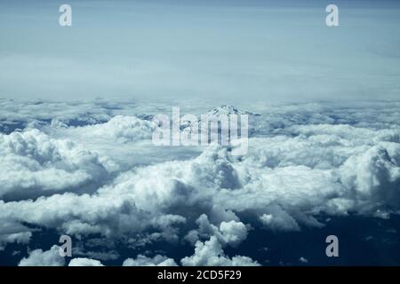 Vista aerea della cima di montagna che si innalza sopra le nuvole Foto Stock