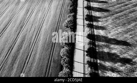 Vista aerea della strada attraverso il paesaggio rurale in nero e. bianco Foto Stock