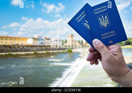 Nuovo passaporto biometrico blu ucraino con chip d'identificazione sullo sfondo della città. Foto Stock