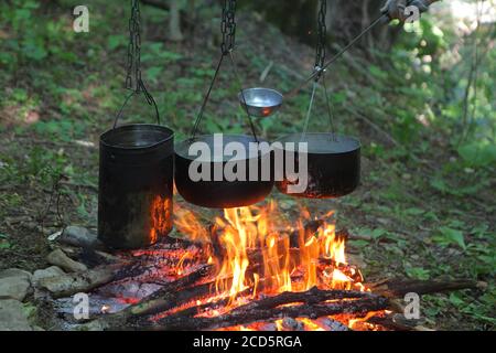 Il cibo è in fase di preparazione su un fuoco nella foresta. Escursione Foto Stock