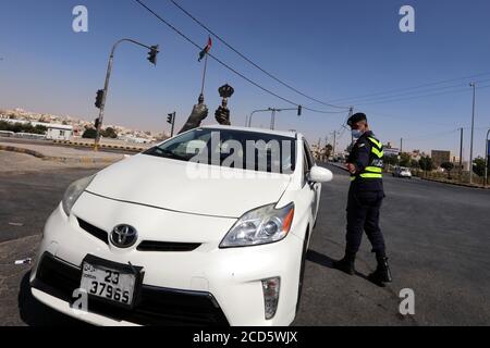 Sahab, Giordania. 26 Agosto 2020. Un poliziotto lavora in un checkpoint durante un blocco nel comune di Sahab, 16 km a sud-est di Amman, Giordania, il 26 agosto 2020. La Giordania ha riportato un decesso relativo al coronavirus e 40 nuovi casi, tra cui 30 infezioni locali, mercoledì, portando la caseload a 1,756 con 15 decessi, ha dichiarato il Ministro della Sanità Saad Jaber durante la conferenza stampa. Credit: Mohammad Abu Ghosh/Xinhua/Alamy Live News Foto Stock