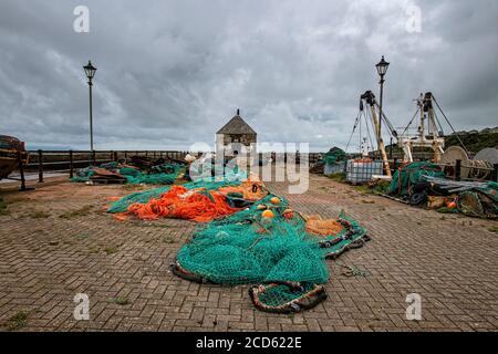 Reti da pesca accatastate sulla banchina a Maryport Foto Stock