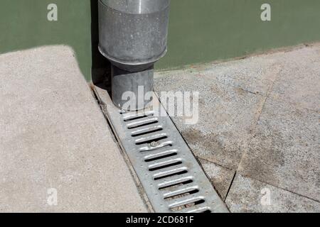 struttura ingegneristica tubo discendente su facciata verde edificio con gocciolatoio di fondo in pietra e con soglia di cemento, closeup dettagli urbani Foto Stock