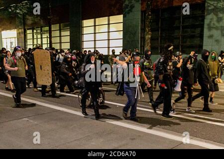 Portland, Stati Uniti. 25 Agosto 2020. Duecento manifestanti hanno attaccato Portland, il municipio dell'Oregon, la notte del 25 agosto 2020, nella 90a notte consecutiva della questione Black Lives e delle proteste per la brutalità della polizia. Alcune finestre sono state rotte e una rivolta è stata dichiarata a circa 11 pm; la polizia ha caricato più volte e fatto arresti multipli. (Foto di John Rudoff/Sipa USA) Credit: Sipa USA/Alamy Live News Foto Stock