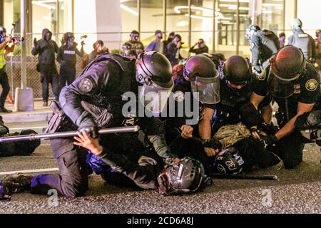 Portland, Stati Uniti. 25 Agosto 2020. La polizia arresta numerosi dimostranti. Duecento manifestanti hanno attaccato Portland, il municipio dell'Oregon, la notte del 25 agosto 2020, nella 90a notte consecutiva della questione Black Lives e delle proteste per la brutalità della polizia. Alcune finestre sono state rotte e una rivolta è stata dichiarata a circa 11 pm; la polizia ha caricato più volte e fatto arresti multipli. (Foto di John Rudoff/Sipa USA) Credit: Sipa USA/Alamy Live News Foto Stock