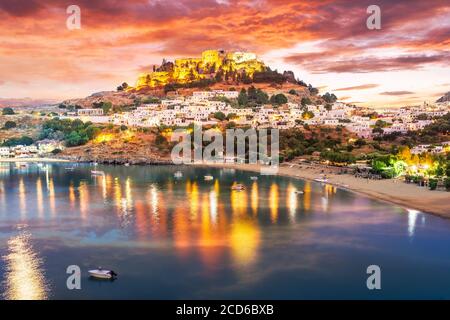 Paesaggio con spiaggia e castello al crepuscolo nel villaggio di Lindos Rodi, Grecia Foto Stock