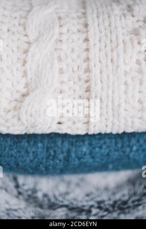 stile di vita invernale e concetto di arredamento domestico, coperte morbide e soffici e pile di lancio Foto Stock